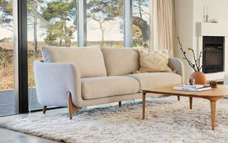 SITS Jenny Sofa featuring plush seat cushions and high legs, photographed in a light neutral fabric